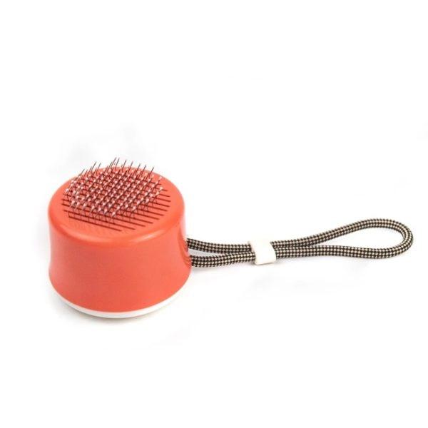 Imagen que muestra el producto Cepillo De Bolsillo Para Mascotas. Cepillo portatil con botón. Material: Plástico, acero inoxidable Color: Rosado, verde DIsponible: Razas pequeñas y medianas