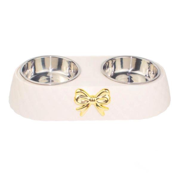 Imagen que muestra el producto Comedero Doble Con Moño. Comedero doble para mascotas cuenta con moño decorativo, bowls removibles y piezas antideslizantes. Material: Plástico, metal
Color: Café, hueso Disponible: Razas pequeñas